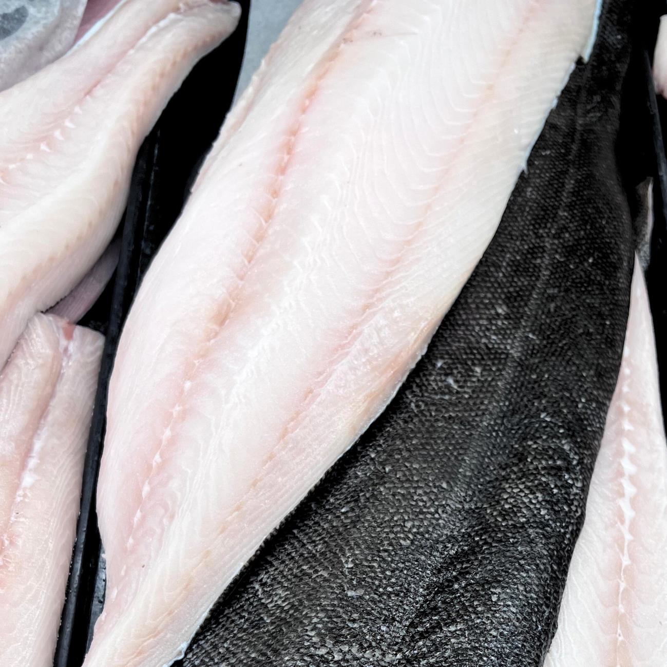 Sablefish fillets with white flesh beside dark, skin-on pieces.
